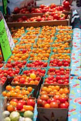 Fototapeta na wymiar Red and Orange Tomatoes in $5 baskets, Farmers Market, Outdoors, August 4, 2019
