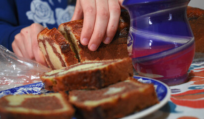 young woman in blue clothes cutting a portion of chocolate pudding into a blue plate