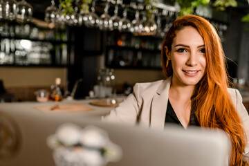 Working redhead woman in a restaurant smiling