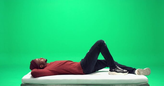 Studio, slow motion, green screen, young man chills out on a white bench, London