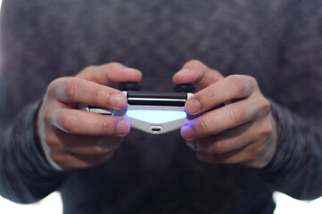 Manos sosteniendo un control de videojuegos, persona jugando videojuegos