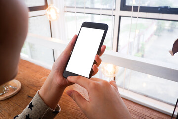 Mockup picture of business woman’s hands/man's hands holding smart phone with white blank screen in modern place.