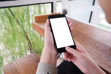 Mockup picture of business woman’s hands/man's hands holding smart phone with white blank screen in modern place.