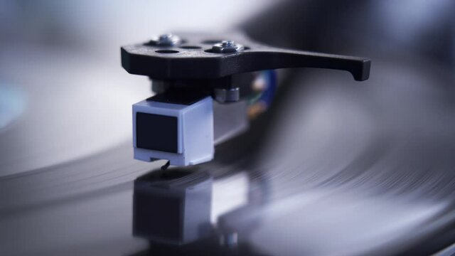 Close up of stylus or needle on turntable with vinyl record spinning