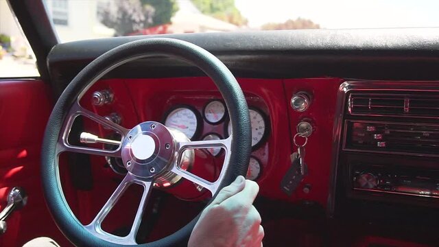 Close-up, man drives a 1968 Camaro
