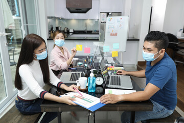 Naklejka premium Group of Asian business people meeting and working at home and wear mask for protect prevent infection covid 19.concecp social distance for New generation business