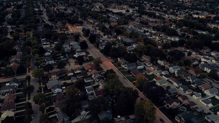 Aerial drone view of suburban neighborhood at  dusk. Establishing shot of American  suburb....