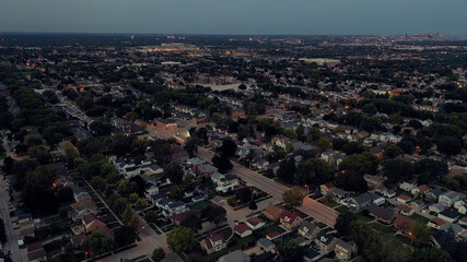 Aerial drone view of suburban neighborhood at  dusk. Establishing shot of American  suburb. Residential houses, night street