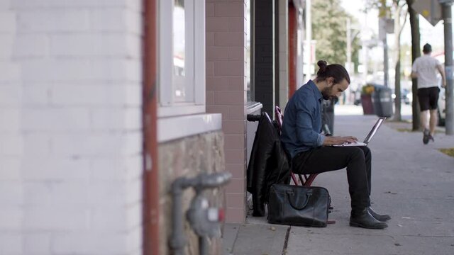  The future of work. Technology worker. Computer programer works outside a remotely creating the next new breakthrough. Shot in 4k. 
