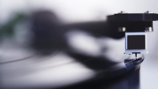 Close up of stylus or needle being lowered onto spinning vinyl record