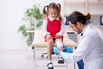 Fototapeta premium Small girl visiting young male doctor