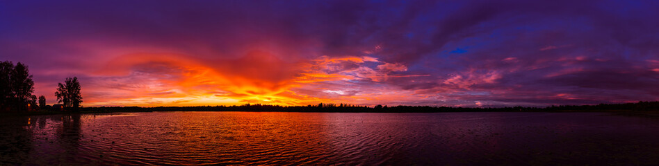 Fototapeta na wymiar Magnificent sunset panorama on an incredible forest lake