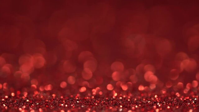 Brilliant background for Christmas and new year holiday. Red moving sniny sequins rhinestones and particles create a beautiful magic bokeh