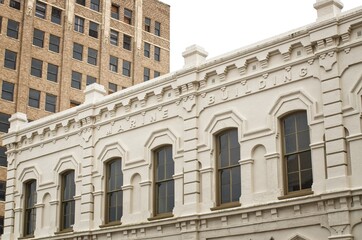 Historic stone building juxtapositioned next to modern building in downtown Galveston Island, Texas