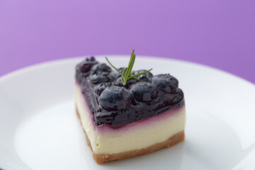blueberry cheesecake  on white plate on violet background