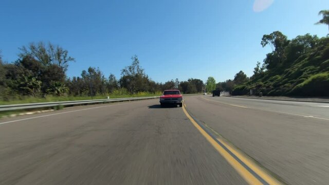 Rear of moving car pov, a 1966 red Chevelle in traffic on a country road, California, USA