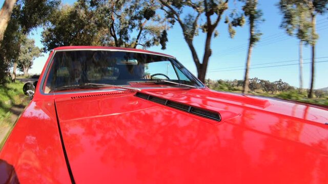 Hood of a car pov, a 1966 red Chevelle in traffic on a country road, California, USA