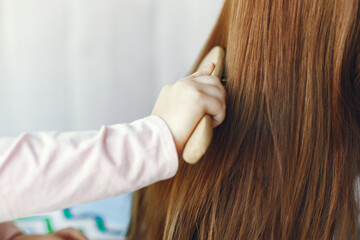 Fototapeta premium Beautiful woman with child. Woman in a white sweater. Little daughter in a room.