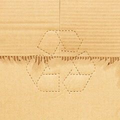 Fototapeta na wymiar Recycle symbol on torn of cardboard sheet background