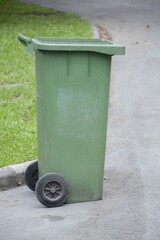 Obraz premium green plastic bin in nature garden