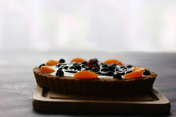 mix fruits pie powood plate orange,blueberry,raspberry,strawberry and low light on window , low light key