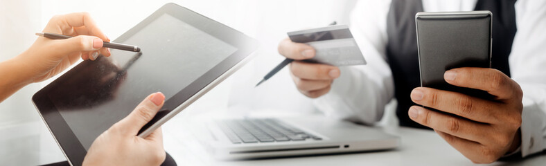 businesswoman hand using smart phone, tablet payments and holding credit card online shopping, omni channel, digital tablet docking keyboard computer at office in sun light