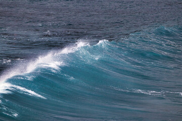 Fototapeta premium Sbstract view of a brilliant blue/green wave breaking to shore.