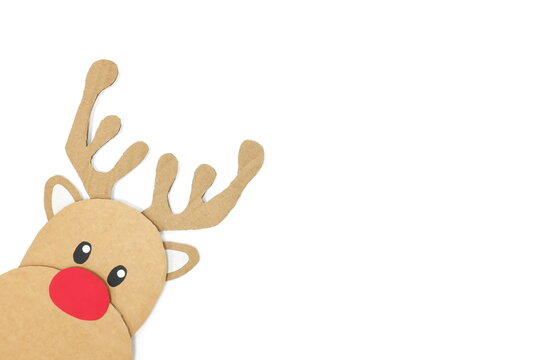 Cute and happy baby reindeer cardboard cutout with red nose peeking on a white background. Christmas is coming and hello december concept with copy space.	