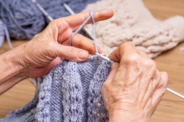 Old woman's hands are knitting