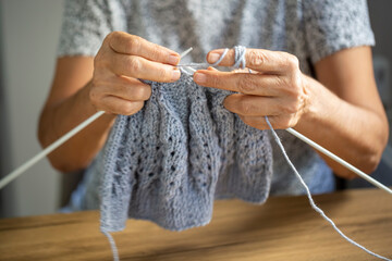 Old woman's hands are knitting