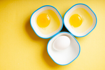 Fototapeta na wymiar Raw egg & yellow yolk in three bowls