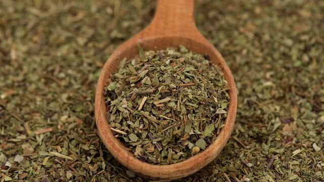 herbs of Provence seasoning for food in wooden spoon and on background rotation
