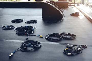 In preparation for a concert, audio cables and speakers are on the stage podium. Event Concept
