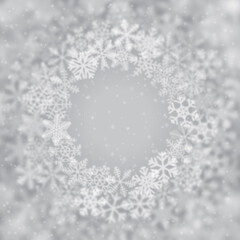 Christmas background of snowflakes of different shape, blur and transparency, arranged in a circle, on gray background