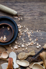 Handmade wooden kitchen utensils, top view lot of billets, spoons and plates on wooden table, selective focus