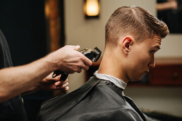 Young man in a barber shop getting his hair clipped