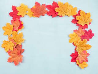 Naklejka na ściany i meble Colorful autumn maple leaves on turquoise background. Flat lay frame