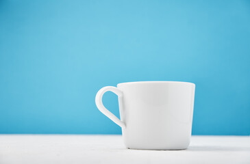 White cup on a blue background with copy space