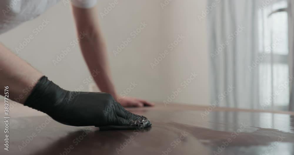 Wall mural slow motion of man hand applying oil finish to toned walnut table with cloth - Wall murals