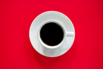 Cup of black coffee on red background 