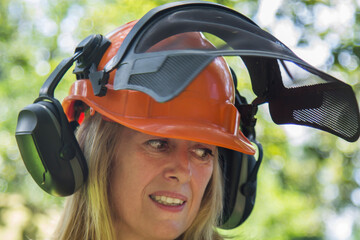 female forester worker with protective helmet in forest