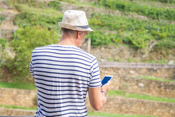 Fototapeta premium tourist with hat and mobile phone in the field