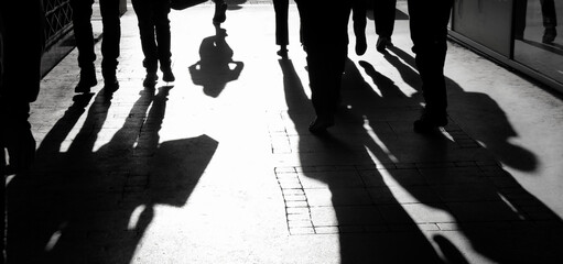 Blurry shadow silhouette of  people walking on pedestrian street in black and white - 382773785