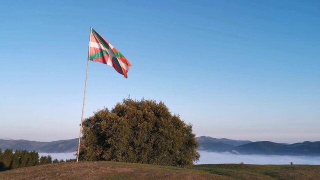 Flag of the Basque Country waving at mountain