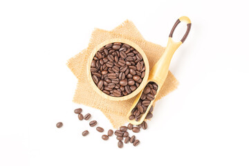 Coffee beans roasted in a wooden bowl and beans scoop on sackcloth over white background. Top view.