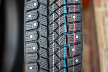 New, black winter car tires with spikes.