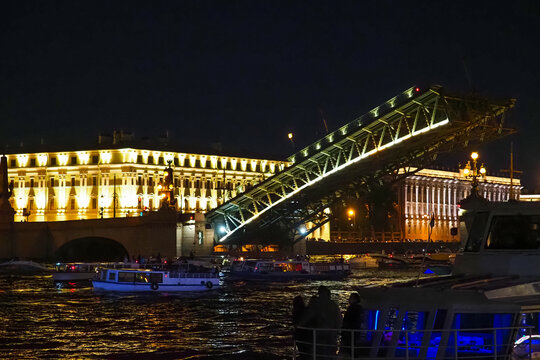 Open bridge in Saint Petersburg, Russia. Troitsky bridge at night. Divorced Troitsky Bridge, river ship on Neva river