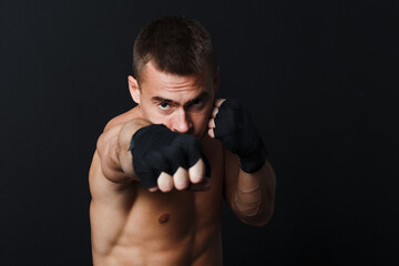 Sportsman man boxer stance punch jab at black background