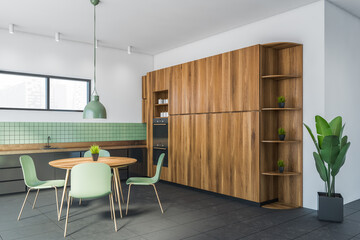White and green dining room corner with bookcase