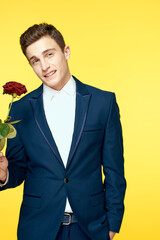 Gentleman in classic suit on yellow background with red rose romance 